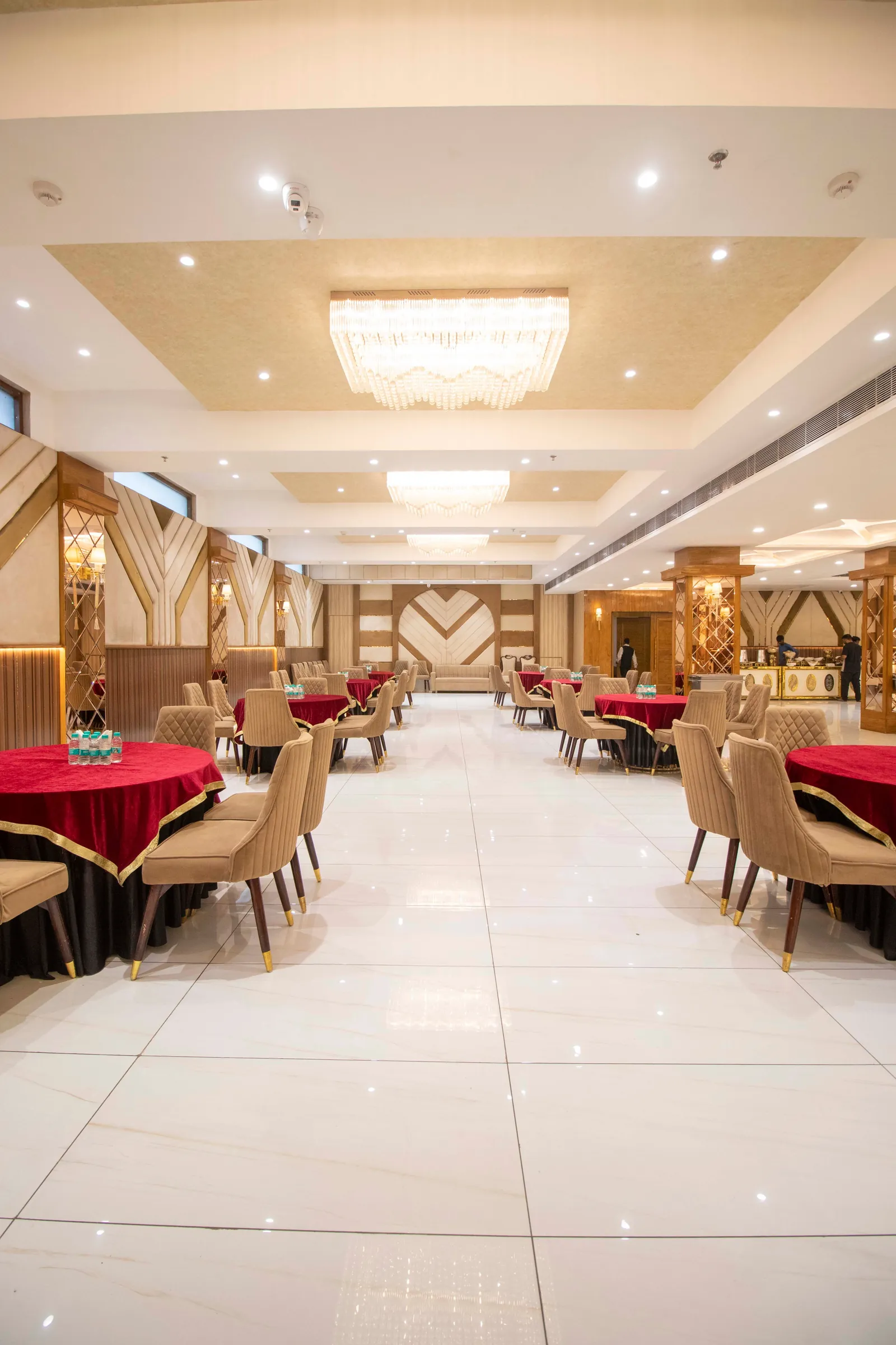 Aisle between round dining tables leading to the far end of the hall
