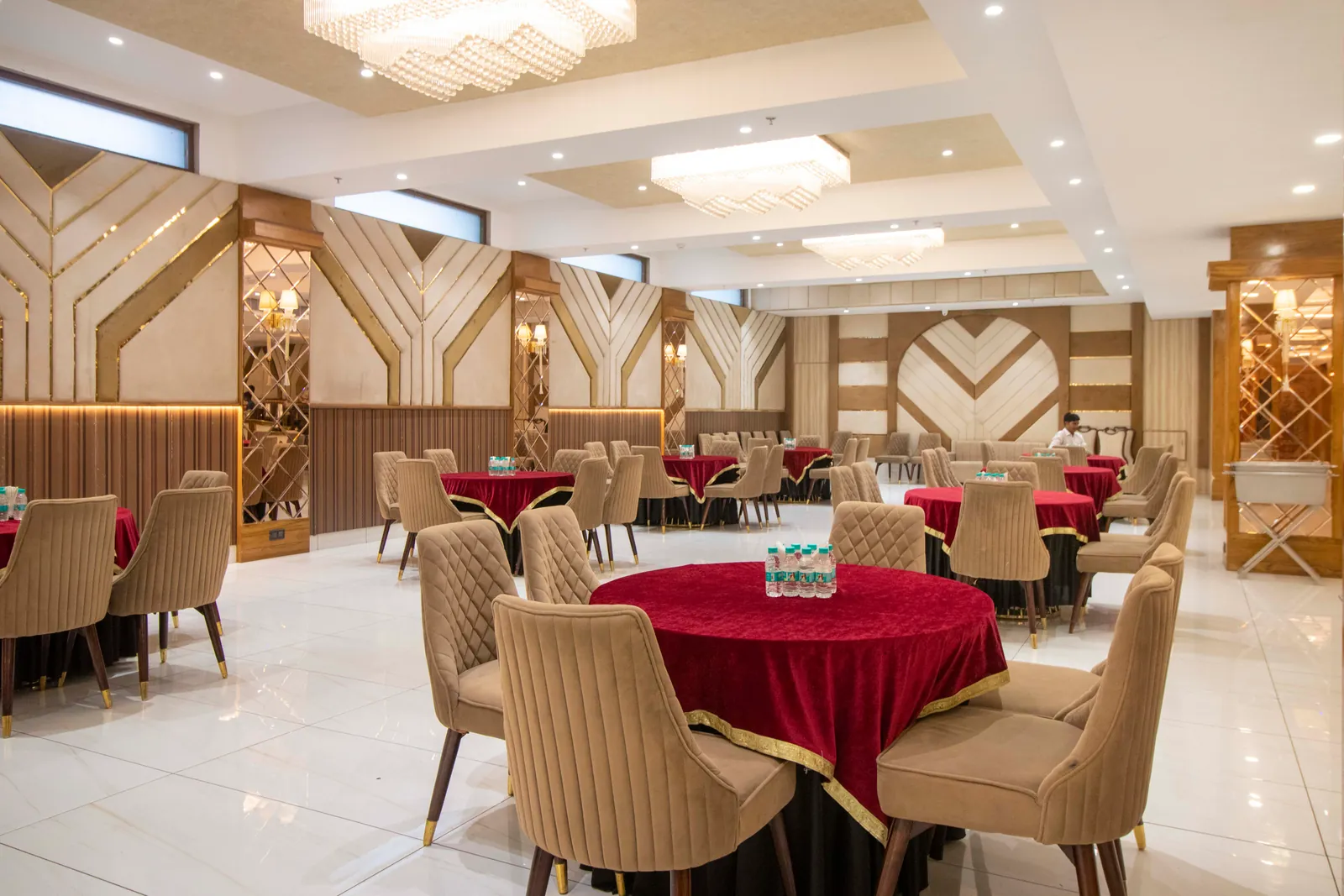 Banquet hall with round tables in red cloth and cushioned chairs