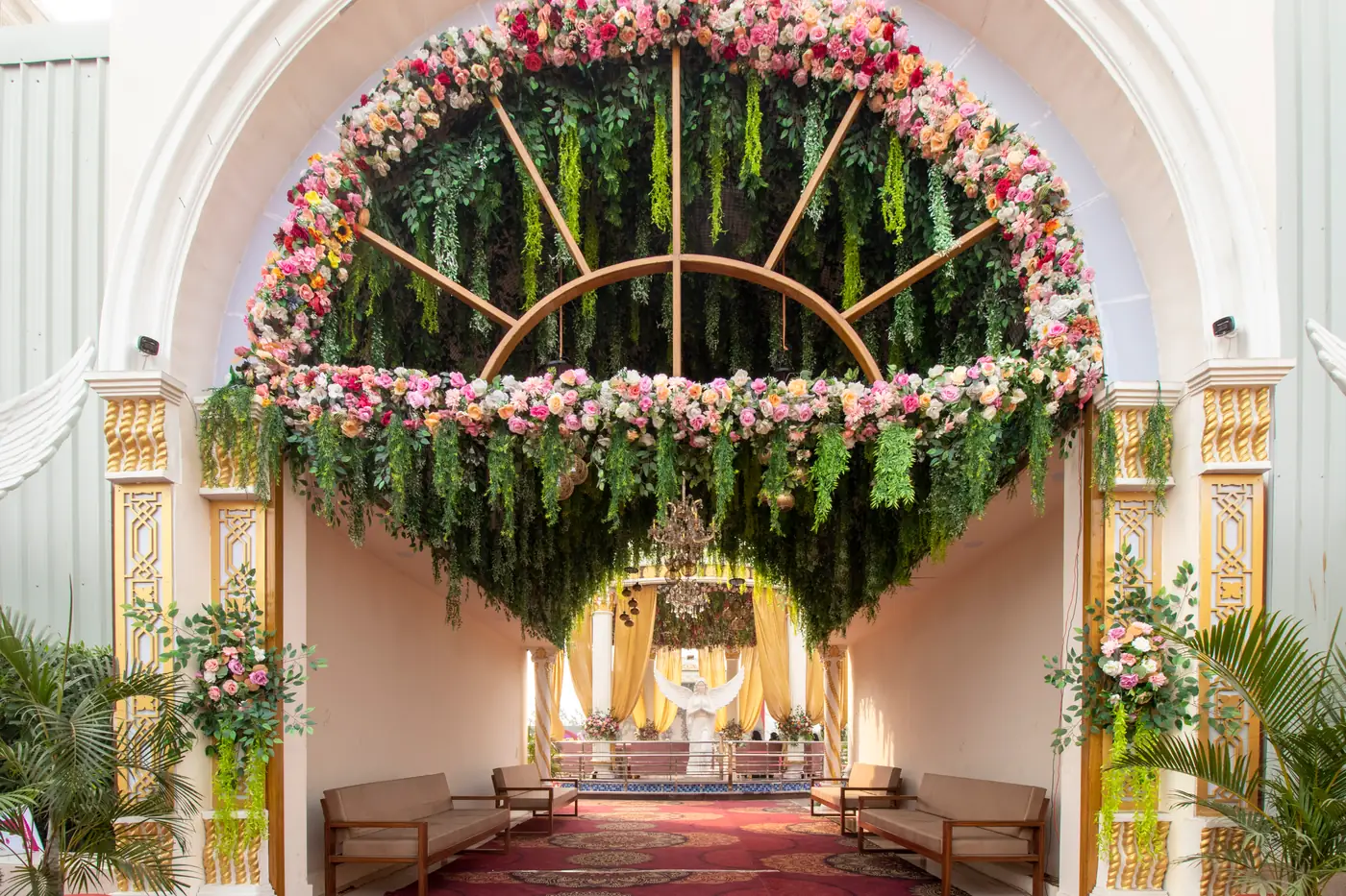 Arched entrance decorated with pink roses and hanging greenery
