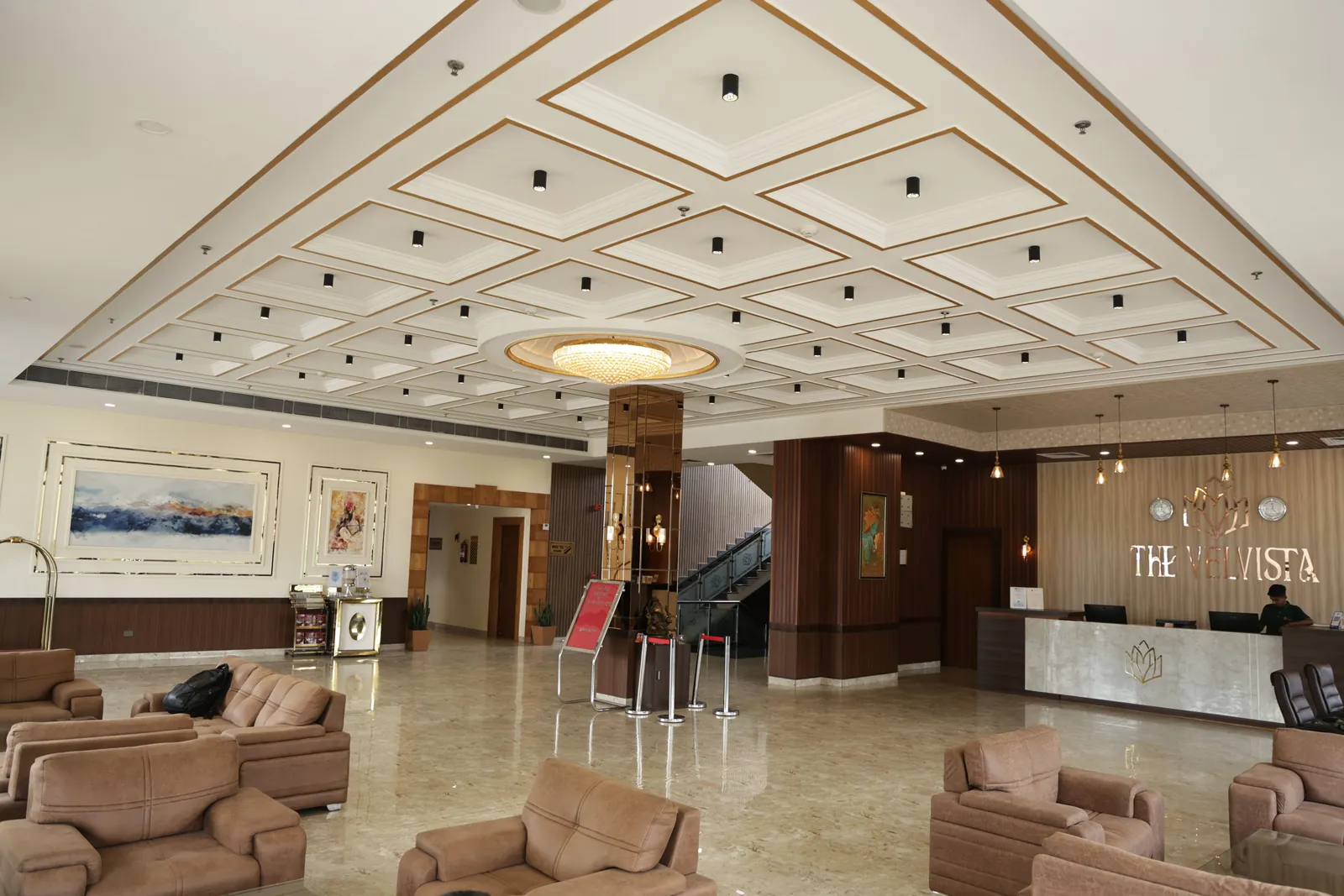 Lobby with a coffered ceiling, sofa seating and the reception desk under The Velvista sign