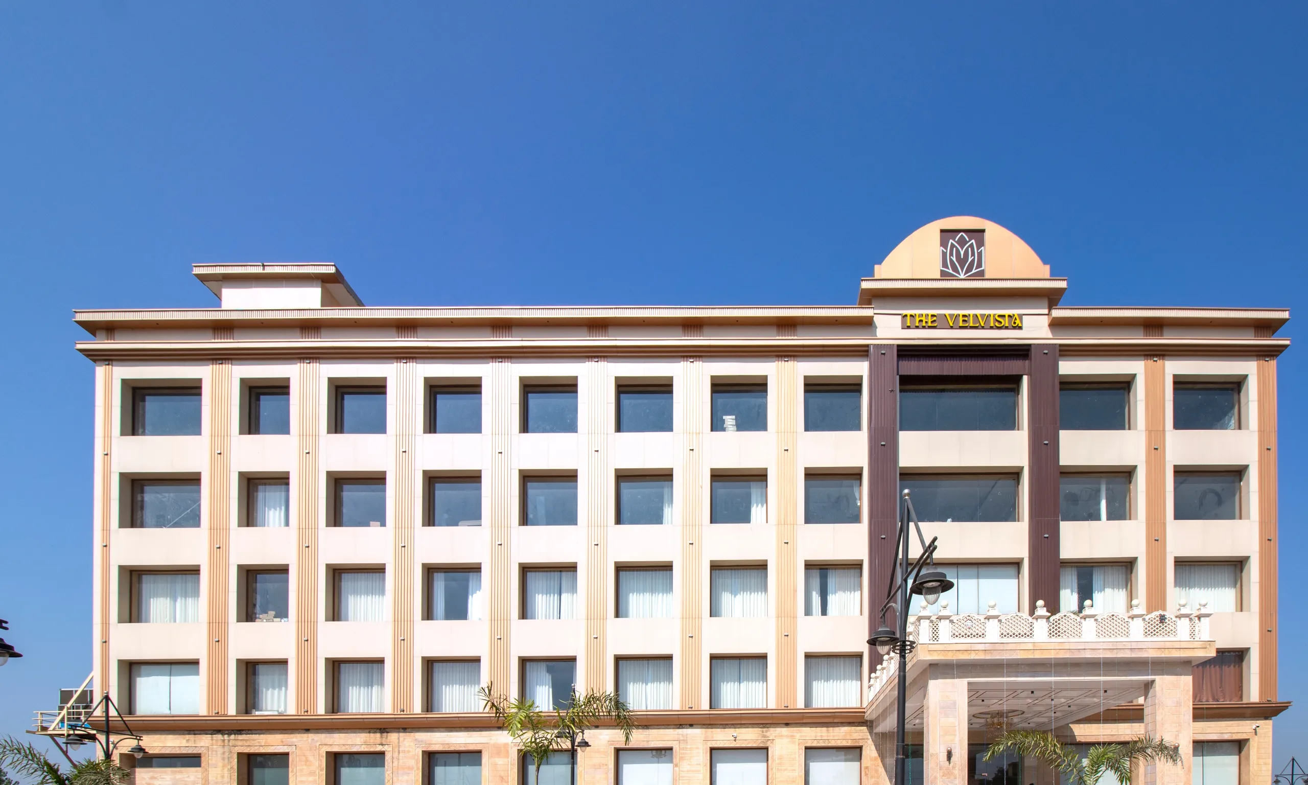 Front of The Velvista hotel building under a clear blue sky