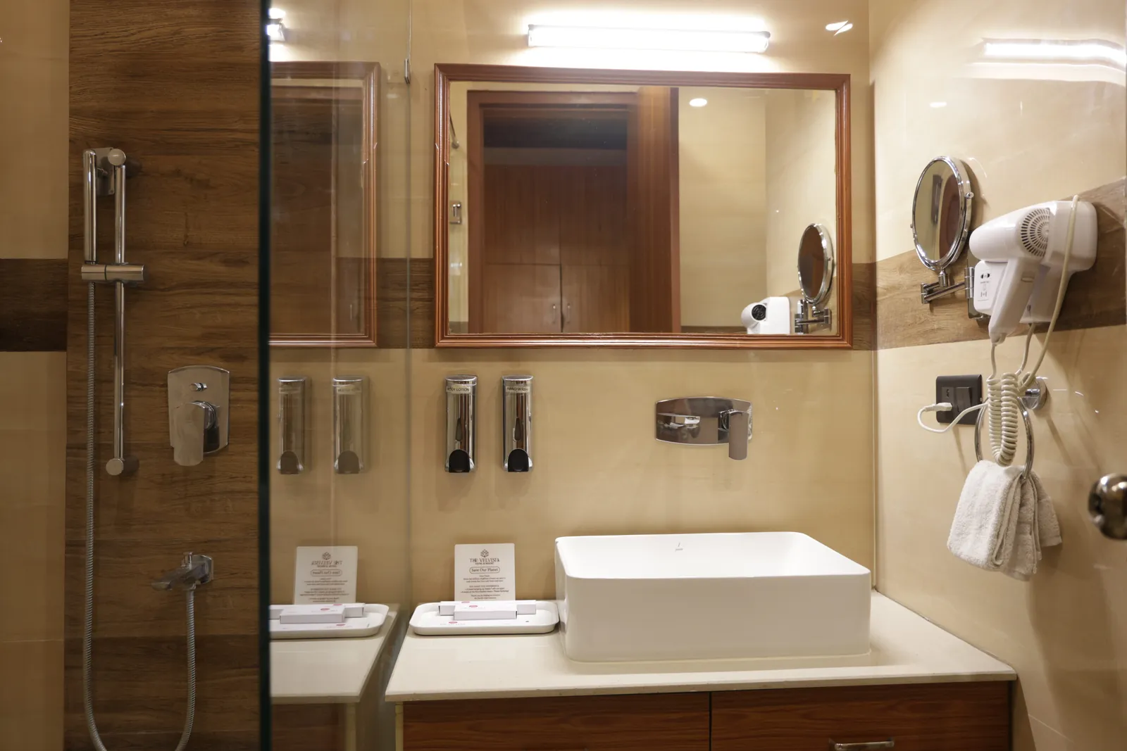 Bathroom with a countertop basin, mirror, hair dryer and glass shower screen