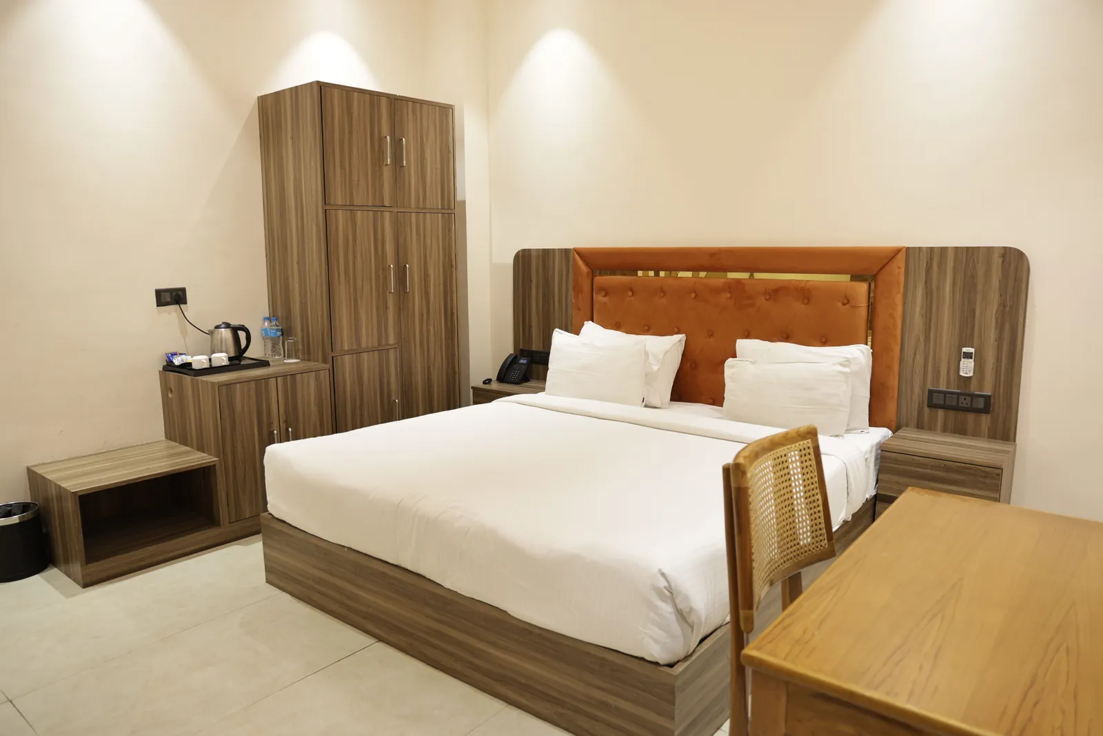 Guest room with a double bed, orange headboard, wardrobe and tea tray