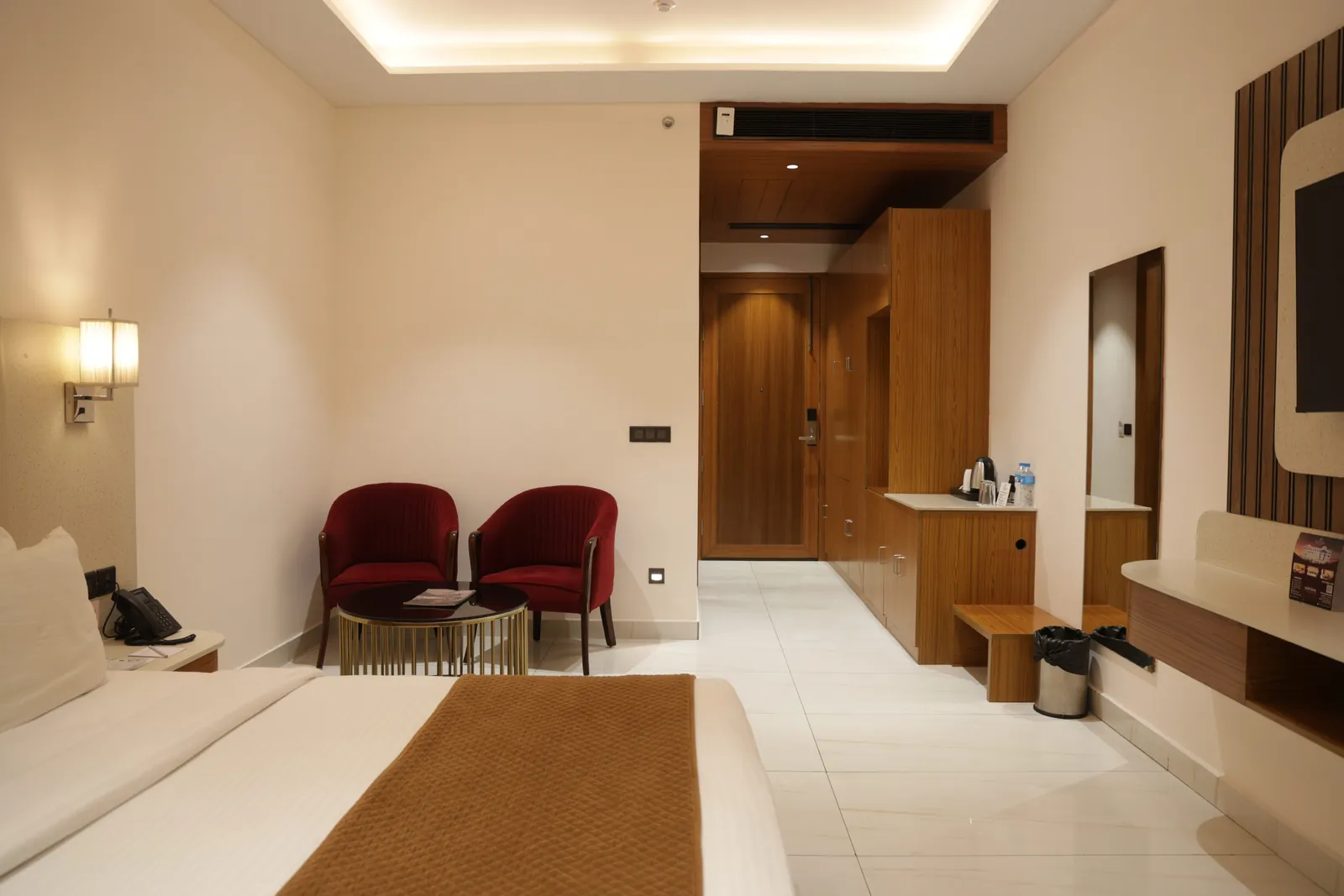 Guest room looking towards the door, with two red armchairs and a tea counter